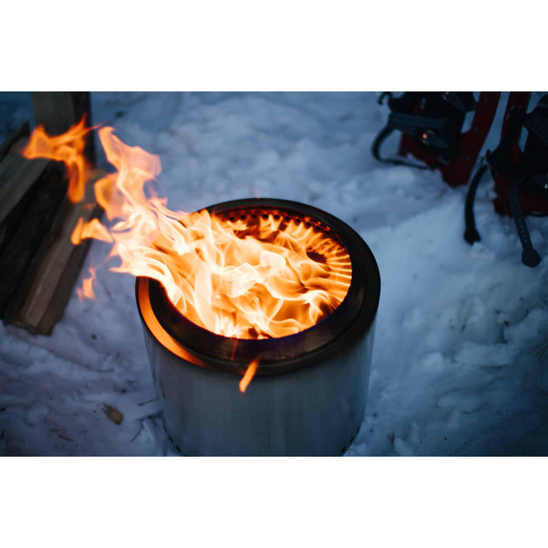 Fire pit with flames burning in a snowy outdoor setting