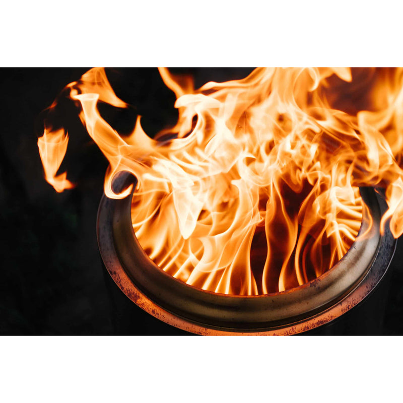 Flames burning inside a metal container on a black background